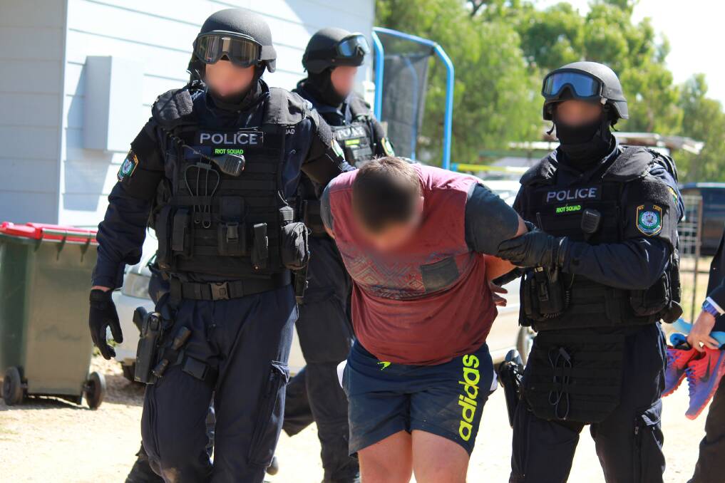Targeted raids: Police from Strike Force Sassafra arrest a man in the operation at Ashley. Photo: NSW Police