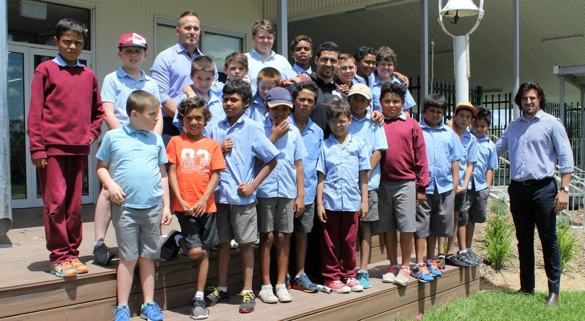 Pindarri director Bradley Commins (back, third from left), South Sydney Rabbitohs player and Pindarri ambassador Cody Walker (middle) and Australian Indigenous rugby union player and Pindarri employee Jordan Goddard (right) with a group of male students from Moree East Public School.