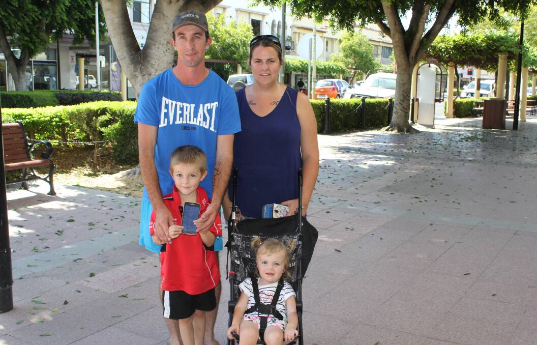 TOO HOT: Young Beau Ross holds up a phone showing just how hot it was in Moree on Tuesday. He is pictured with his parents Andrew and Kelly and little sister Amber.