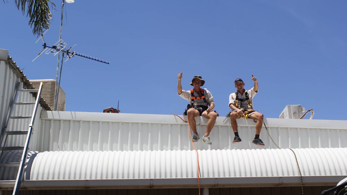 FEELING HOT: Crawford Roofing and Asbestos Removal's Jarrad Bradford and Priit Kivivare were all smiles, despite sweating it out on top of a roof in Wednesday's heat.