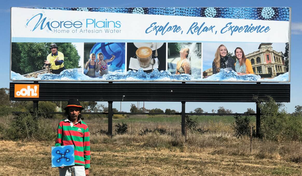 PROUD: Local Aboriginal artist David 'Crockett' Craigie holding his original artwork which was incorporated into the design of the new road signs.