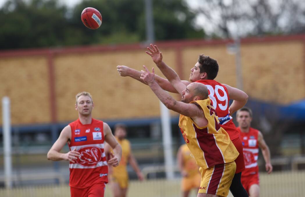 TUSSLE: The Suns' Jared Lidgerwood contests the ball against the Swans' Nathan Bradburn during the match in Tamworth two weeks ago. Photo Gareth Gardner