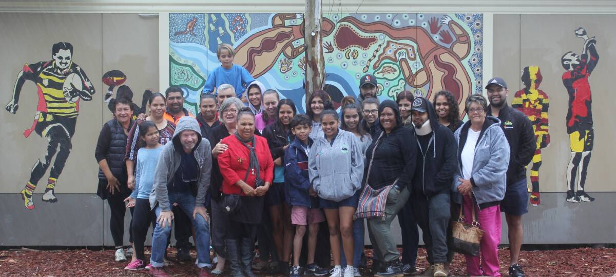 BOOMIES PRIDE: Paste-ups of Boomerangs players can be spotted around town as part of the First on the Ladder project. Pictured is Boomerangs players, students from Barwon Learning Centre and artists with some of the paste-ups on the wall at Barwon Learning Centre.