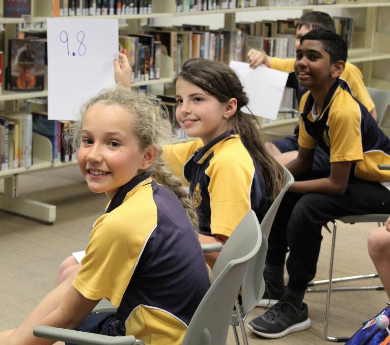 The audience judges hold up their scores during the Australian Poetry Slam heat at Moree Community Library.