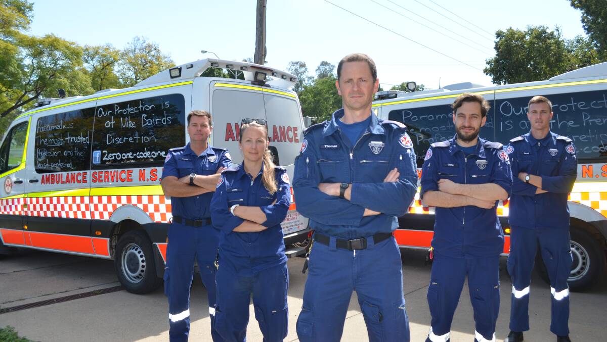 RELIEVED: Moree paramedics David Farrell, Jess Crandon, Tom Claringbold, Brad Hartley and Luke Hegedus pictured with the slogans they wrote on their ambulances last year. Photo: Laini Kirkman