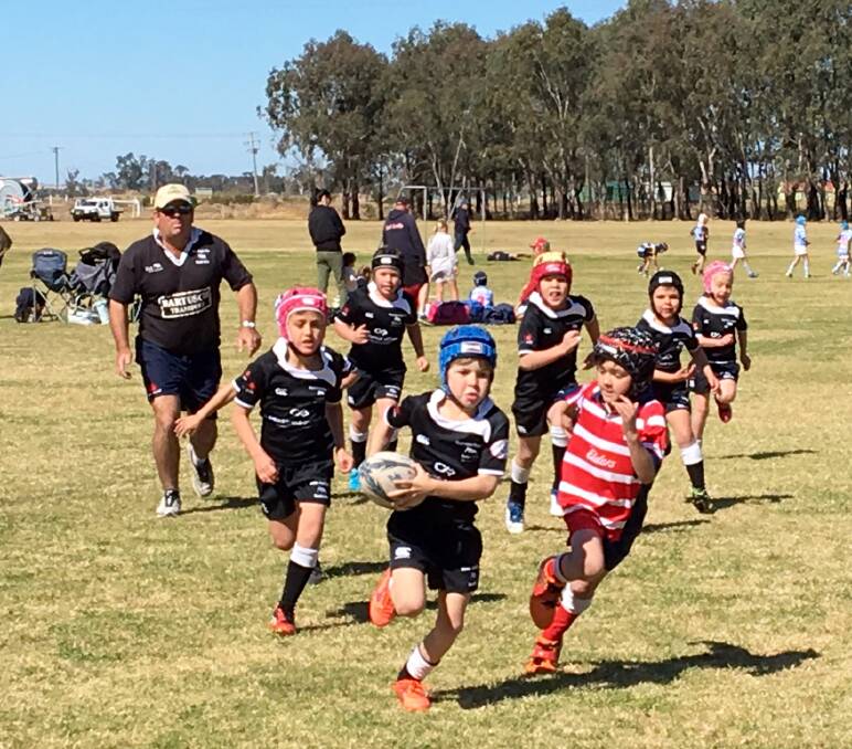 Making a break: Jock Kirkby runs the ball in the under 8s against Walcha at the weekend.