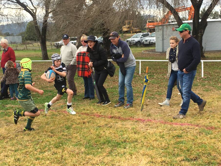 Hitting the gaps: With some Moree supporters cheering him on, Angus Manchee races down the side line against Inverell in the U10s game.