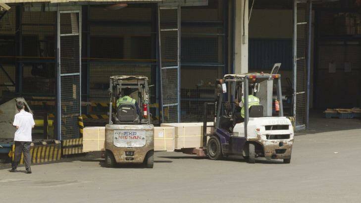 Coffin's of Andrew Chan And Myuran Sukumaran being lifted on forklifts at Jakarta Airport.   Photo: James Brickwood