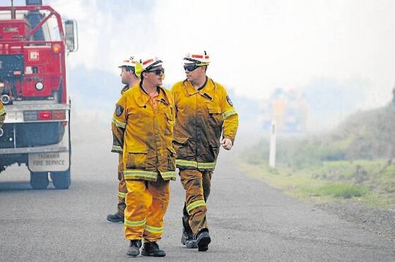 Firefighters discuss tactics at the fire at Lefroy yesterday. Photo Geoff Robson