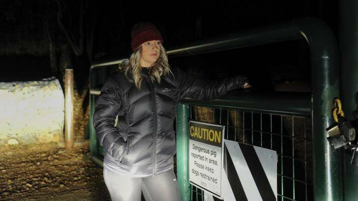 Michaela Vodvarka at Mount Jerrabomberra near a sign warning of a dangerous pig. Photo: Melissa Adams