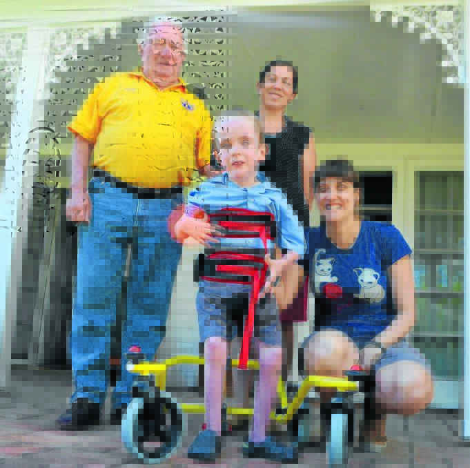 Local Lion Barrie Brooks, Anne Conroy and Cerebral Palsy Alliance physiotherapist Anna te Velde watch Bailey test out his new wheels before school.