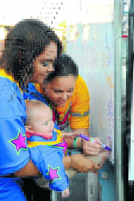 Sheena Fernando with Cooper Townsend and Holly Bartram trace his foot to write a note on Ellie's message board.