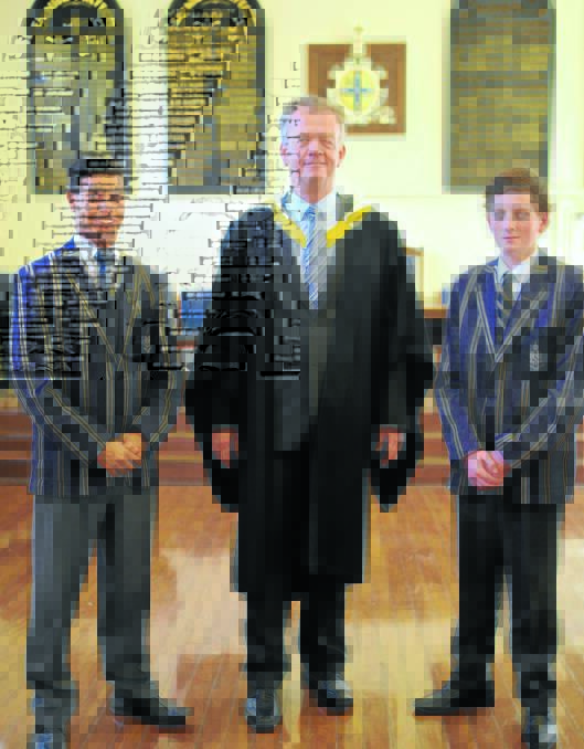TAS headmaster Murray Guest congratulates Wayne Mumbulla and Nicholas Druery after the leaders induction service on October 17.
