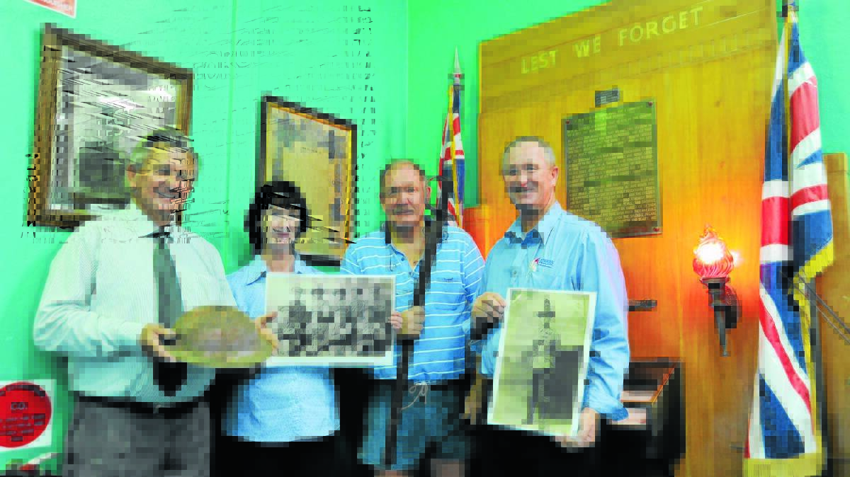 John Tramby, Karen Munn, Steve Ritchie and Brendan Munn hold photographs and artefacts for the display.