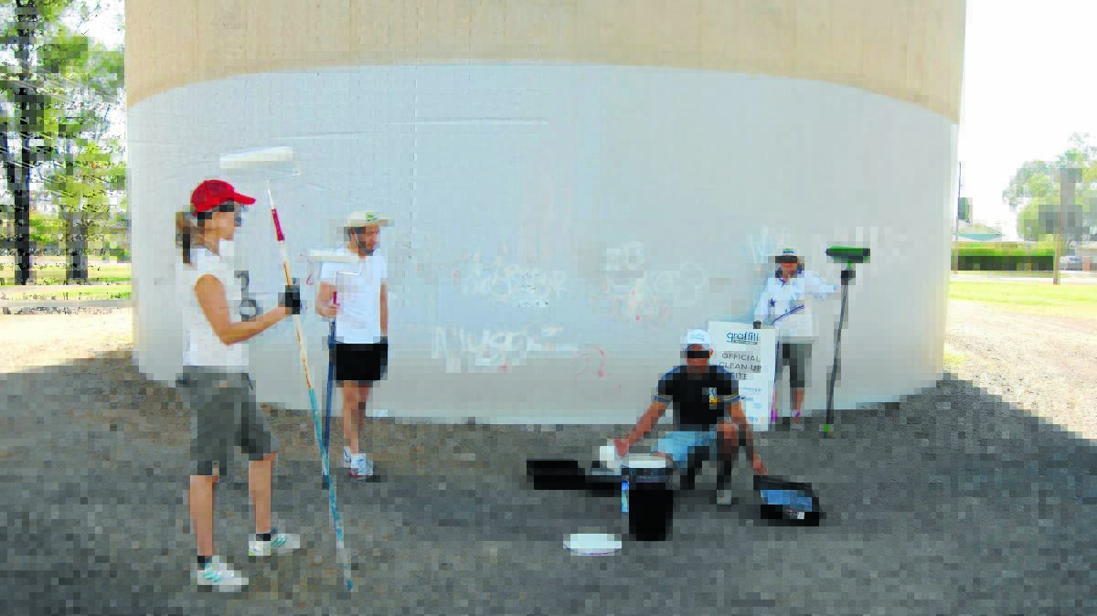 Volunteers set to paint over the graffiti at the Jellicoe Park water tower.