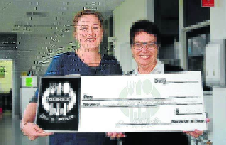 Moree on a Plate volunteer and local midwife, Sarah Bagshaw, presents Moree hospital acute health service manager, Bronwyn Cosh, with a donation from the successful event.