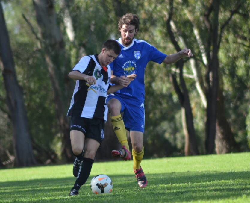 Alex Madden (right) jostles for possession during Moree FC's loss to North Companions earlier this season.