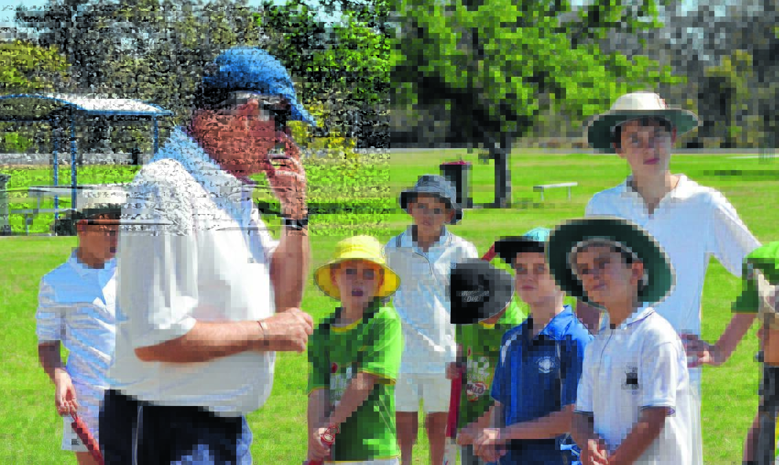 Geoff Dymock explains some of the basics of cricket to young players yesterday.
