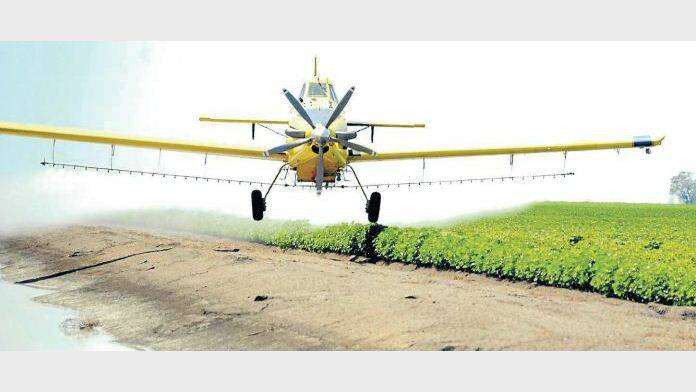 A crop duster sprays a local cotton field. 