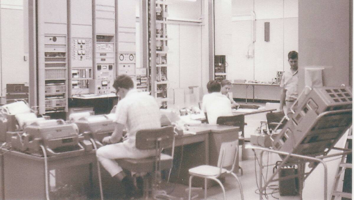 Employees working at the station, with the old switchboard in the background.