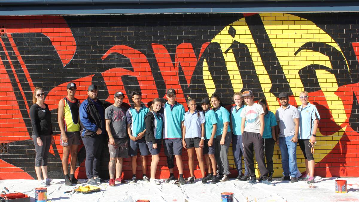 Moree Secondary College students have been working with Brisbane street artist Warraba Weatherall (fourth from left) and Moree Plains Gallery curator Hannah Williamson (left) to create the impressive mural.