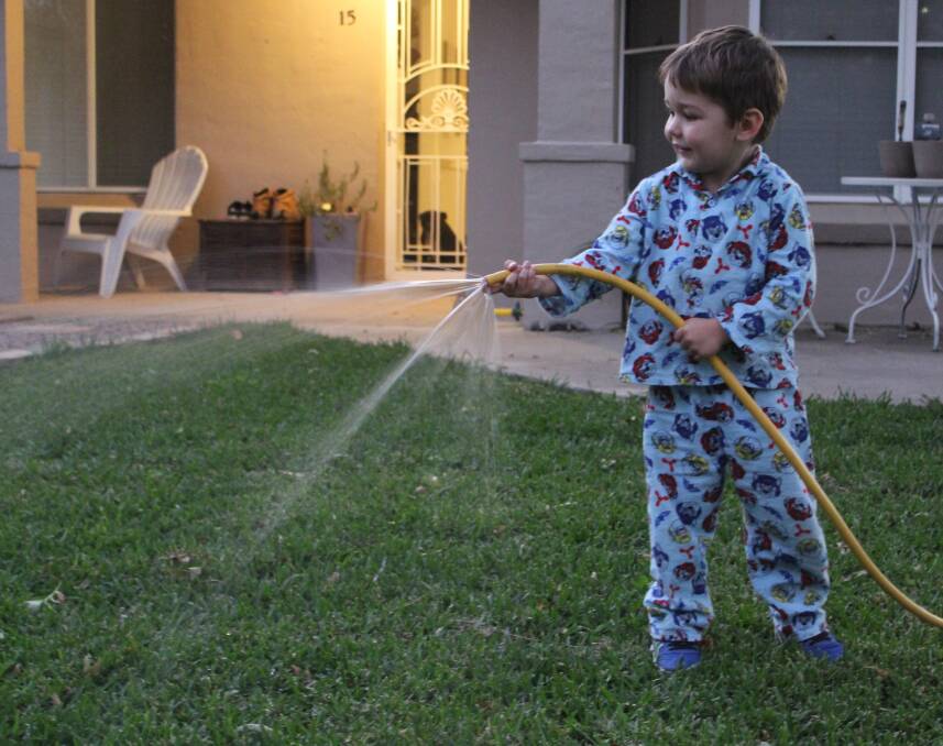 Three-year-old Andy Moss enjoys helping mum and dad water the lawn.