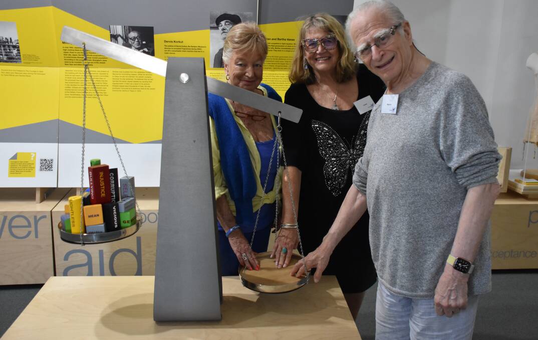 Courage to Care chief volunteer Jeanie Kitchener with Holocaust survivors Eva Engel and Maurice Linker, who demonstrate one of the interactive parts of the exhibition which shows that the more people who come together, the easier it is to overcome injustice.