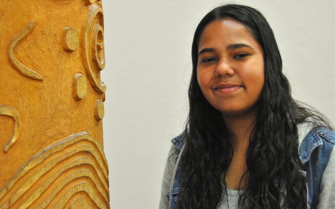 Standing near the Lawrence Leslie carved silky oak tree at the Dhiiyaan Aboriginal Centre, Jenica Haines-Creighton is enjoying her workplace experience.
