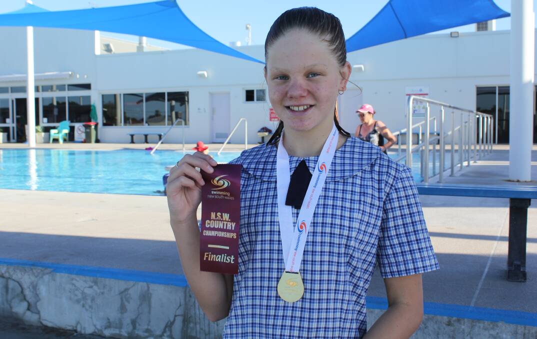 Ava Macey with her gold medal for winning the 10 years girls 100m breasstroke event and ribbon for placing fourth in the 11 years 50m breaststroke.