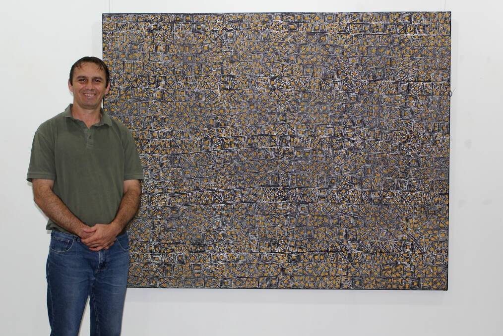Keith Munro with Maria Josette Orsto's detailed piece 'Miyinga (Scars)', which is part of the 'Being Tiwi' exhibition.
