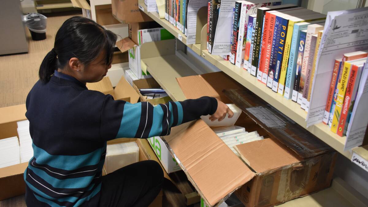 REAL LIFE EXPERIENCE: Year 10 student Patty Zou packs and organises new DVDs coming into the library