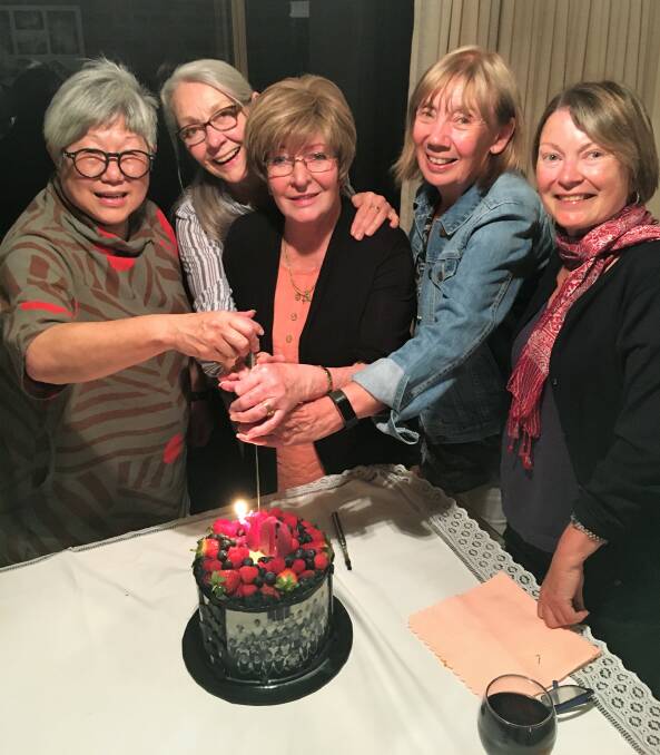 Susan Pingkee, Carole Carter, Toni Houlahan, Anne Findlay and Glynis Pearce cut their birthday cake, which featured their school photos digitally imposed around it. Photo: supplied