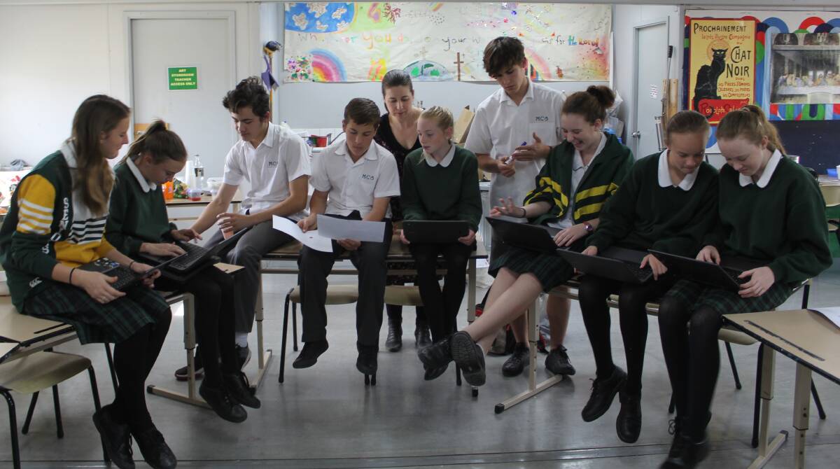 CREATIVITY FLOWING: Talitha, Eden, Joshua, Matthew, Jaylee, Jordan, Michelle, Lucy and Alison work on their story, watched on by Ms Barklay (back). Photo: Natalija Stanojevic