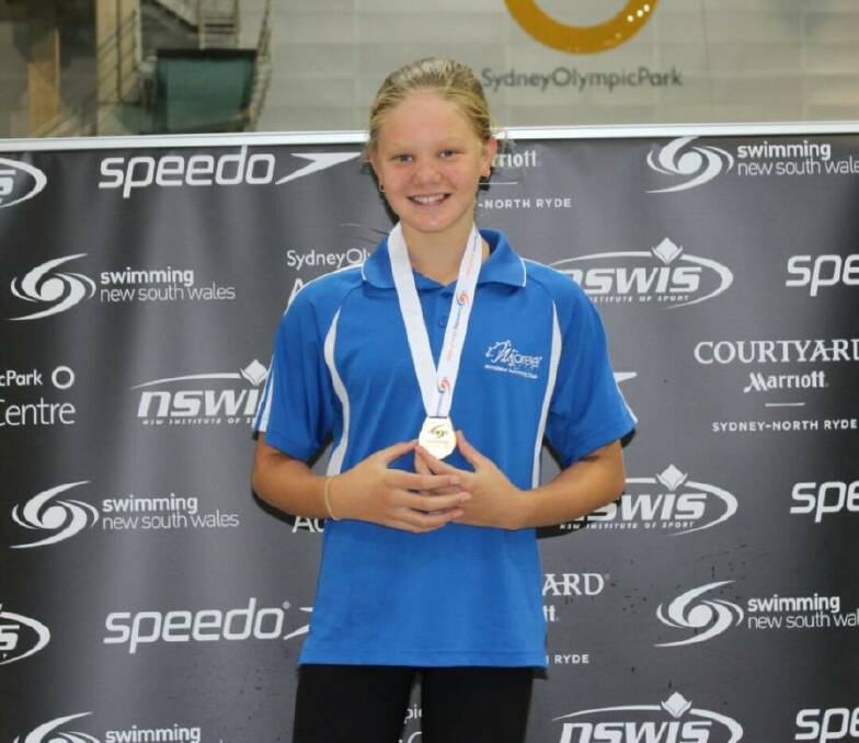 Ava Macey on the winner's podium at Sydney Olympic Park Aquatic Centre.