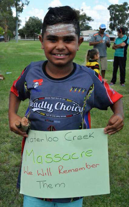 HEALING: A young Aboriginal boy proudly holds up a sign remembering the victims of the Waterloo Creek Massacre during last year's Survival Day.