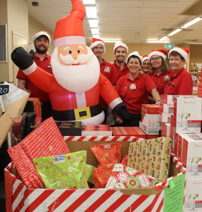 GIVING: Coles Moree staff David Retallick, Shane Gray, Nathan Bennett, manager Fran Moore, Bobby Moore, Emily Dyball and Julie Harris with the box full of gifts.