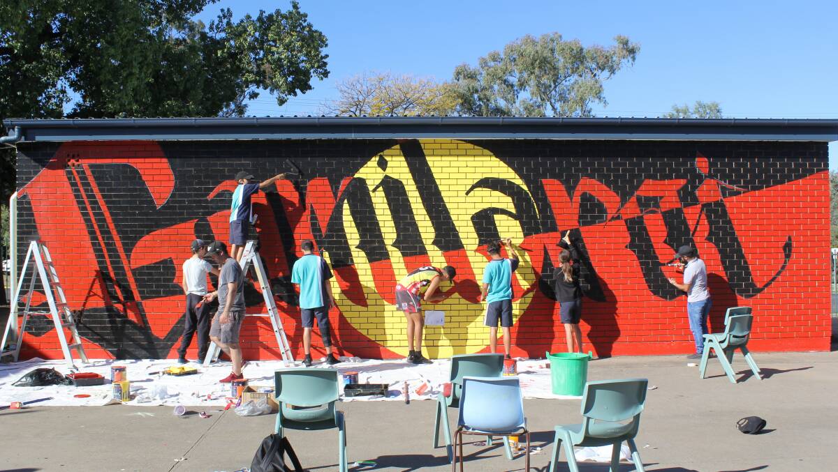Students busy painting the mural.