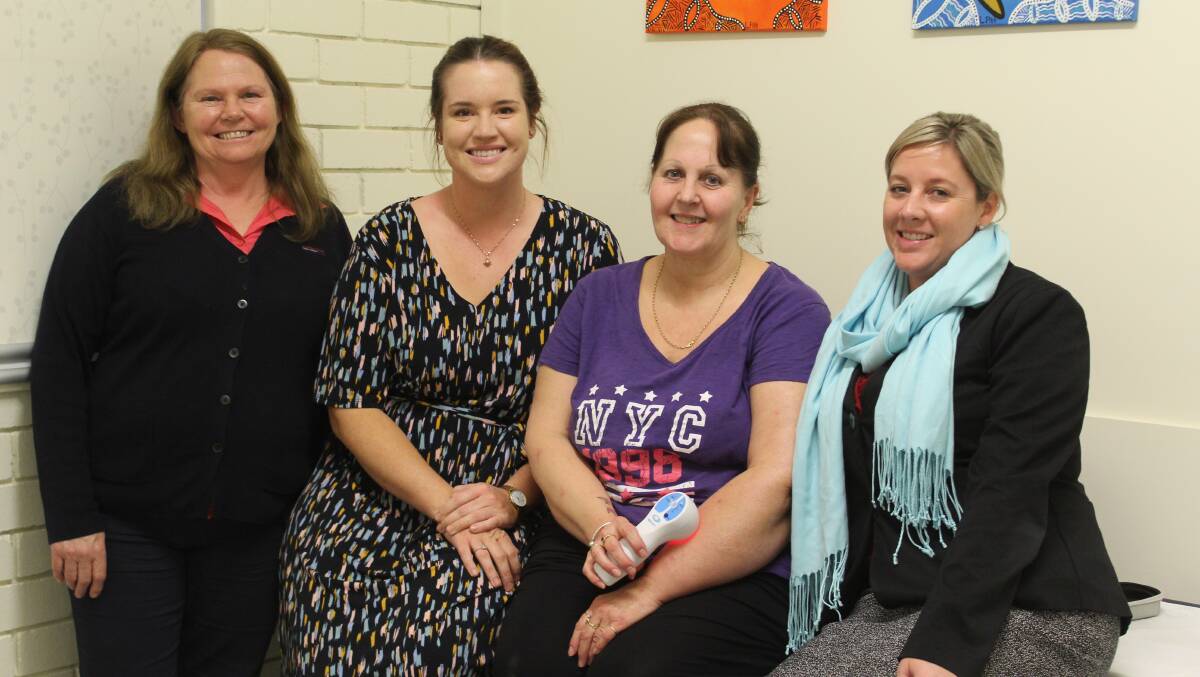 McGrath Breast Care nurse Wendy Allen, Moree Ladies Day committee members Nicole Youngberry and Laura Colley (right) with Tracie Miller (second from right) who shows how the laser works on her arm.
