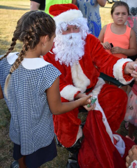COMING TO TOWN: Santa Claus handed out lollies at last year's Christmas at Twilight event. The jolly man will once again be taking time out of his busy schedule to make an appearance at this year's carols event on Friday.