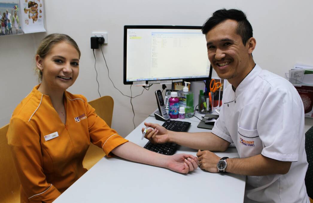WINTER READY: Moree Discount Drug Store pharmacist Hafiz Dostizada gives a flu vaccination to staff member Josie Bussell. For every vaccination, $2 will be donated to help vaccinate impoverished children in India.
