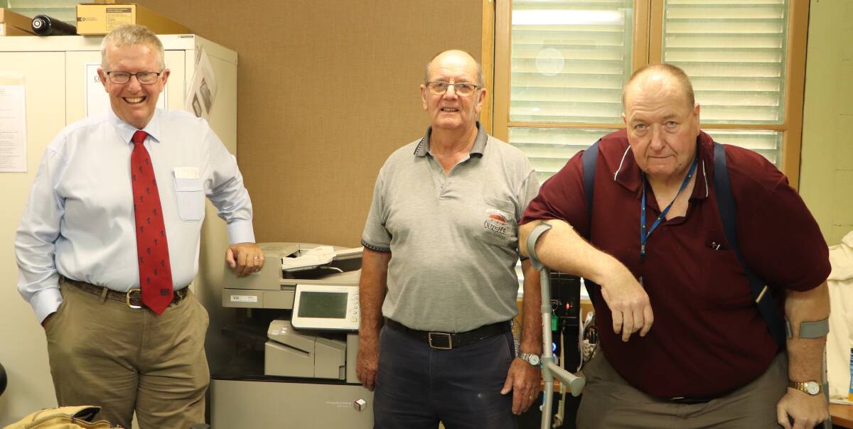 Federal Member for Parkes Mark Coulton, Moree and District Historical Society Vice President James Pritchard and member Michael McNamara with the old printer/scanner.
