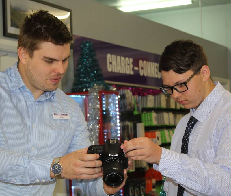 ON THE JOB: Harvey Norman franchisee Chris Smyth showing work experience student Liam Fenton the functions of one of the store's cameras.