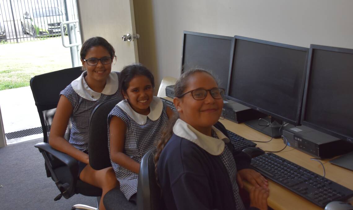 Talara Munro, Shiara Saunders and Denna McGrady sitting in front of the computers donated by Boyce Chartered Accountants.