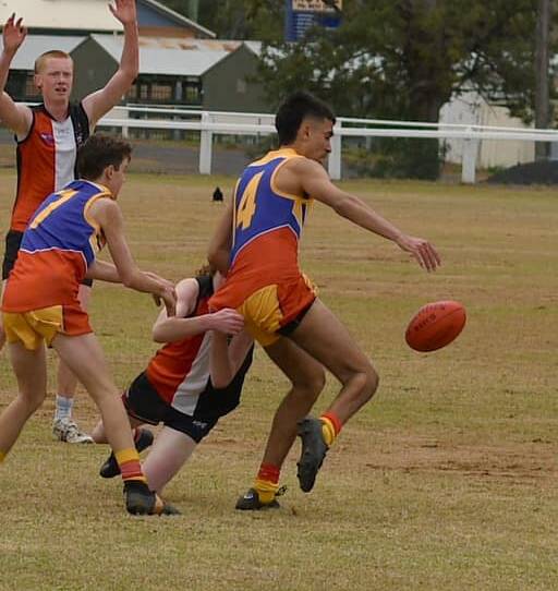 MOVE IT ON: Bradley Swan kicks the ball out of trouble for the Moree Suns under-17s in their match against the Inverell Saints. Photo: Moree and District Suns AFL Club.