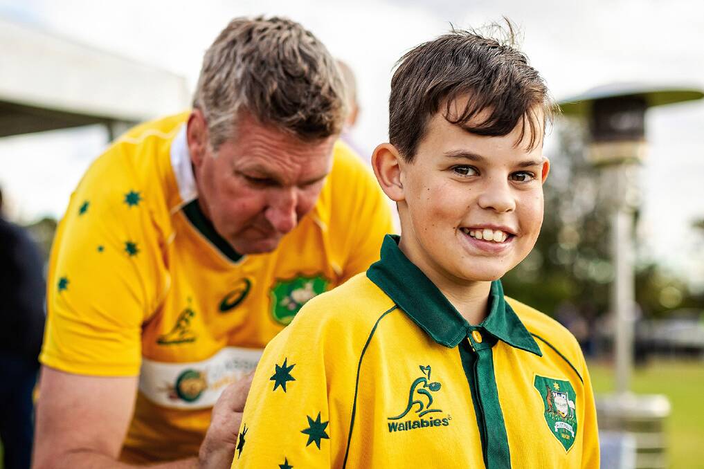 EXCITED: Classic Wallabies player and general manager Justin Harrison signs a young fan's jersey.