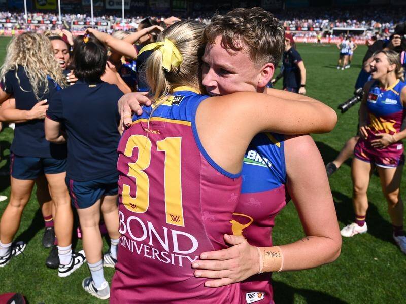 Dakota Davidson (R) hugs Taylor Smith after playing a vital role in Brisbane's grand final triumph. (Joel Carrett/AAP PHOTOS)
