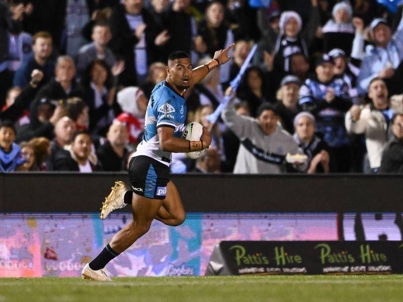 Ronaldo Mulitalo runs away in front of celebrating Cronulla fans during the win over the Dragons. (James Gourley/AAP PHOTOS)