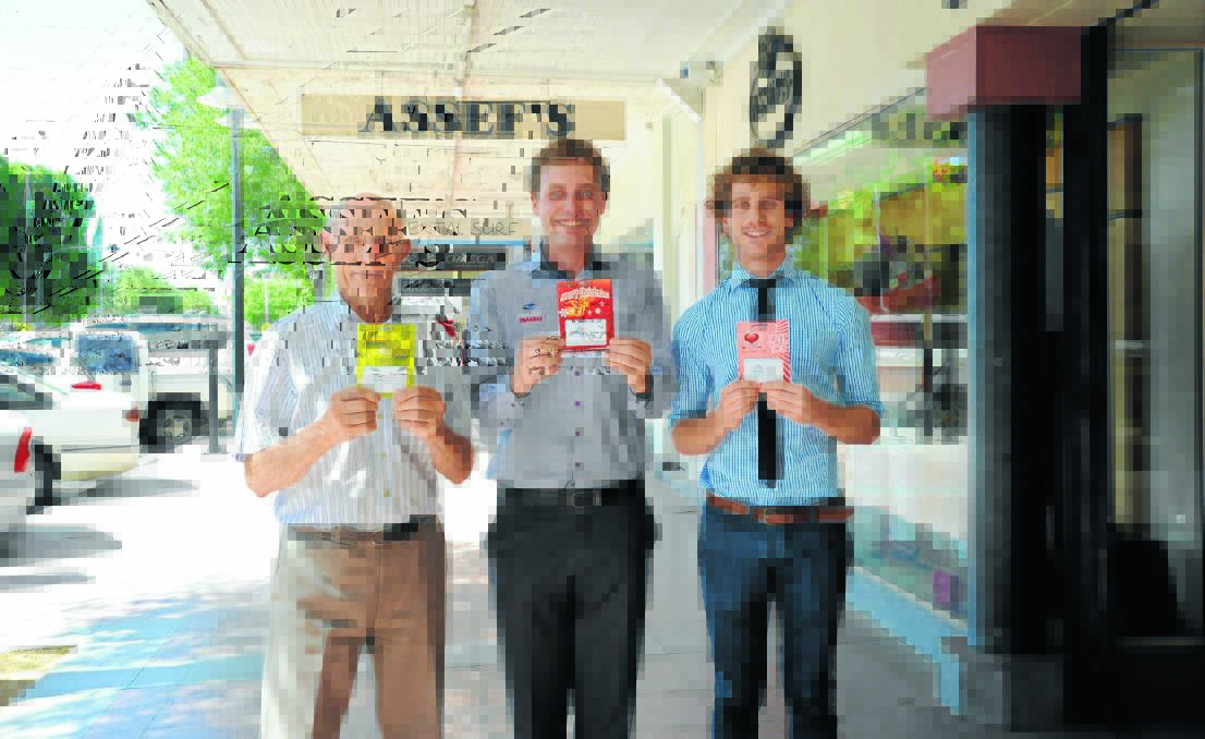 Chamber members John Atkins, David MacLellan and Daniel Assef with the cards. Just a few of the participating businesses in the main street are Assef’s, Cafe Omega and Shoe Elegance. 