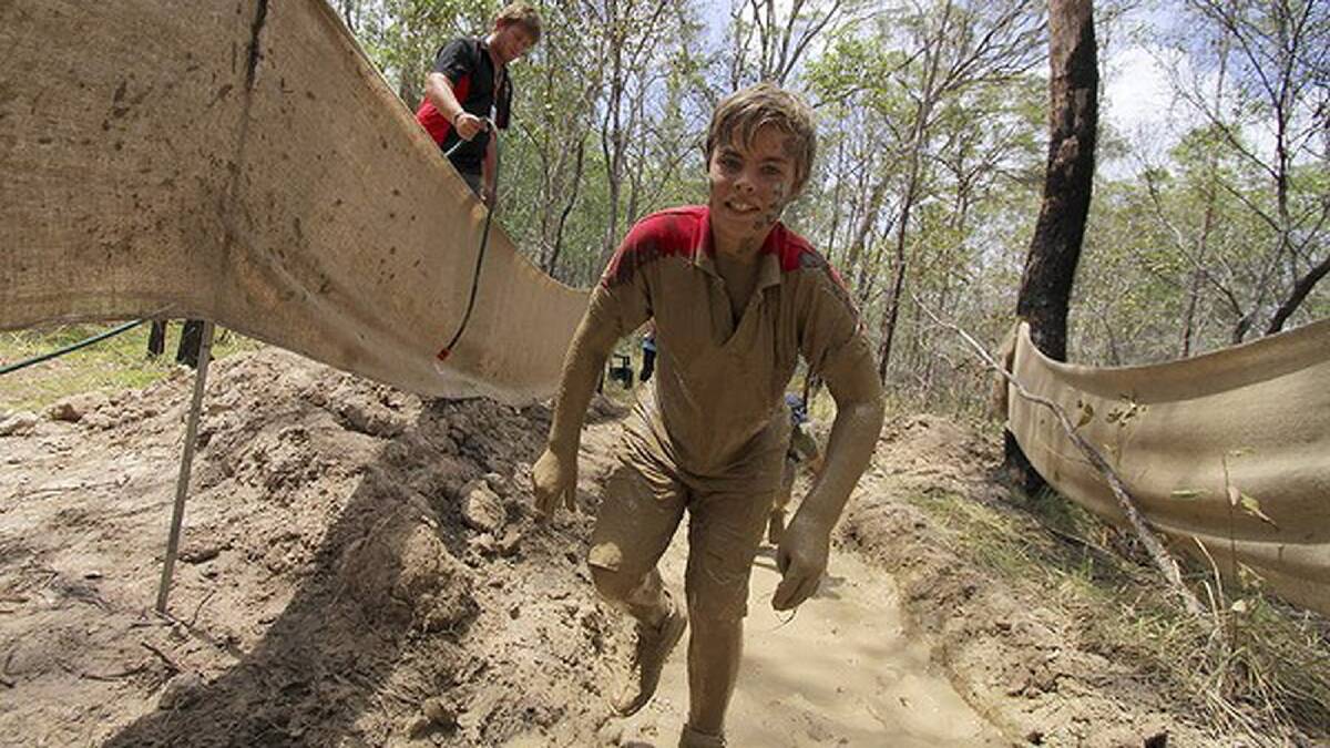 Daniel McLeod, 12, from Nagambie, Victoria, goes through the mud obstacle course. Photo: Michelle Smith
